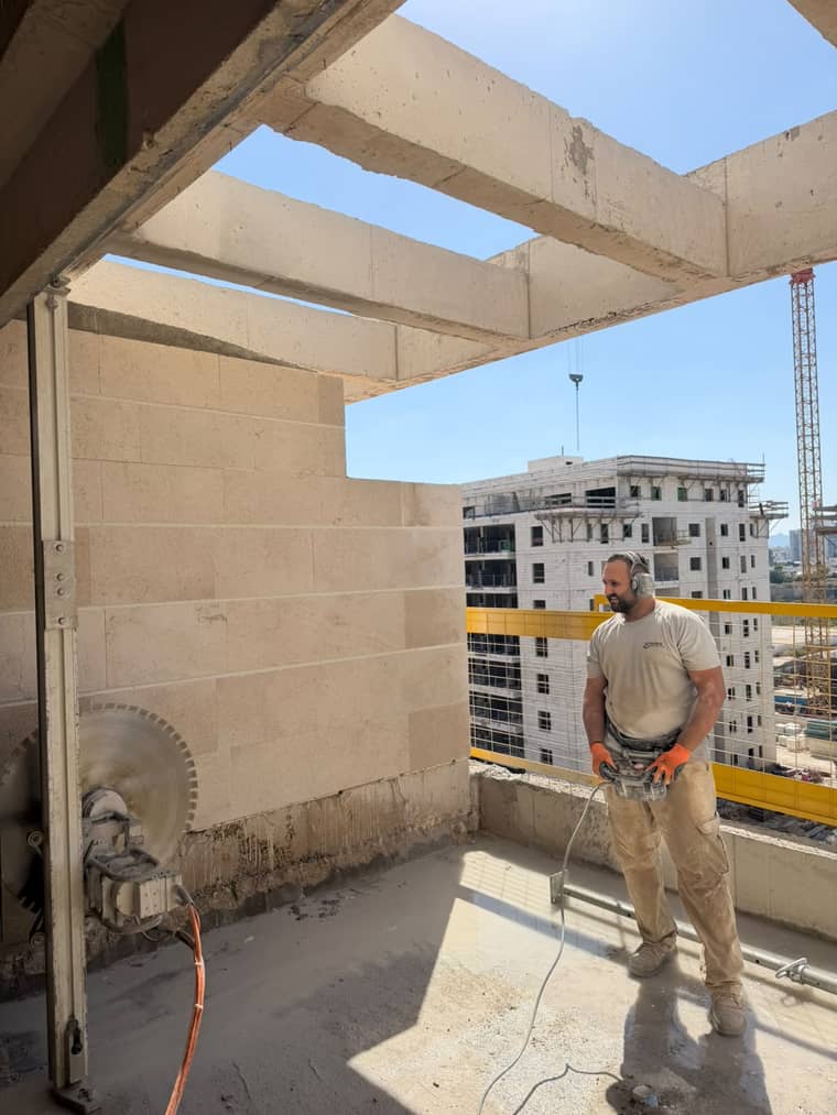 לידור עם ציוד ניסור מול פתח שנוסר בקיר בטון