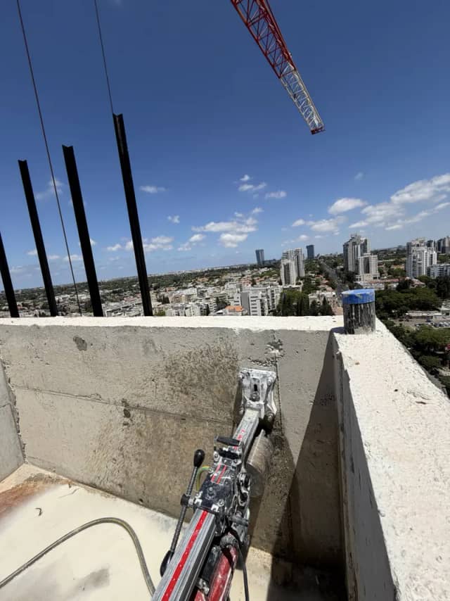 קידוח בטון על גג מבנה עם קו רקיע של העיר